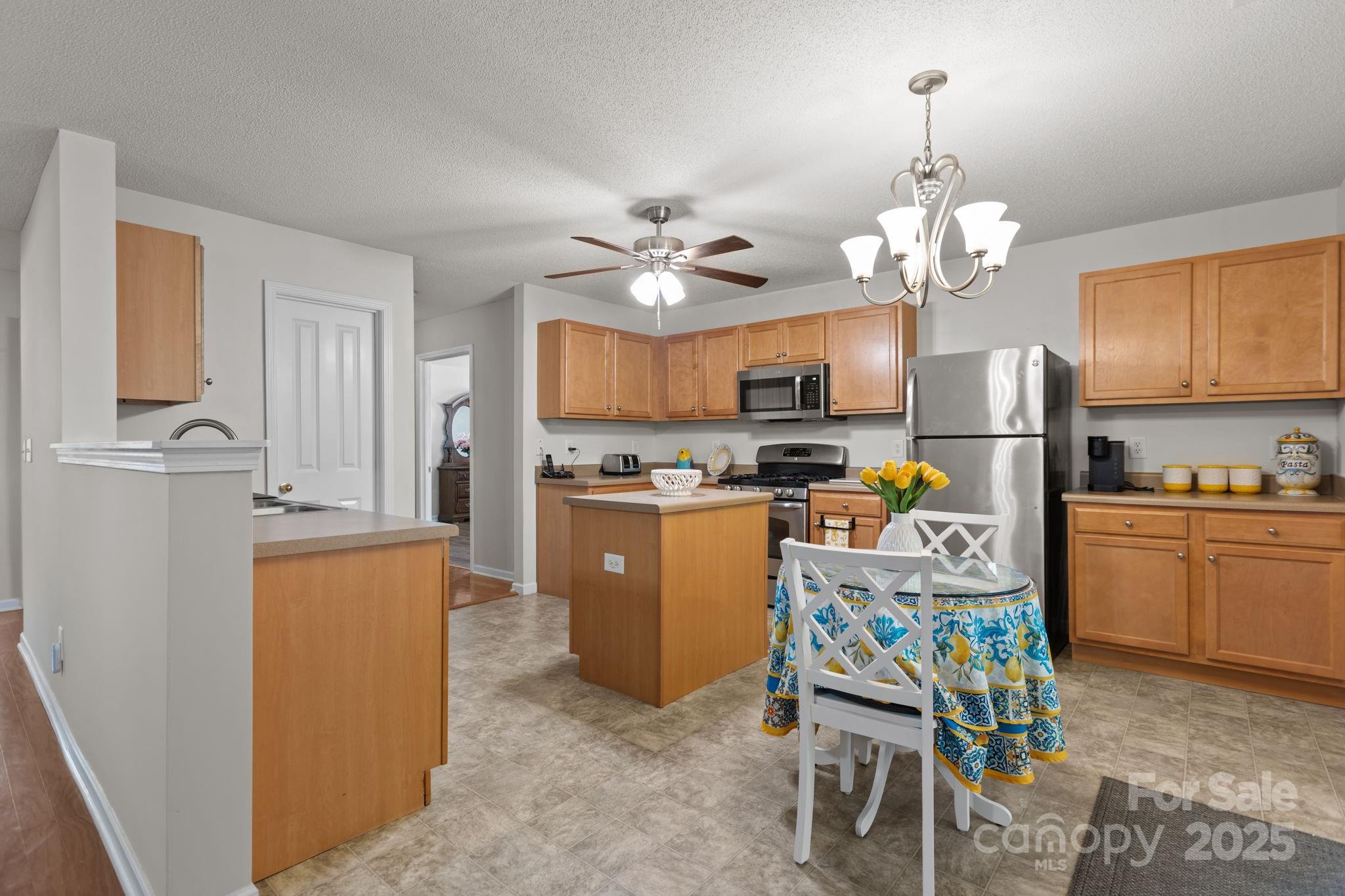 6839 Harter Court, Unit 35 Raleigh, NC 27610 - Photo 13 of 43 a kitchen with stainless steel appliances granite countertop a refrigerator a sink dishwasher a stove and a dining table with wooden floor