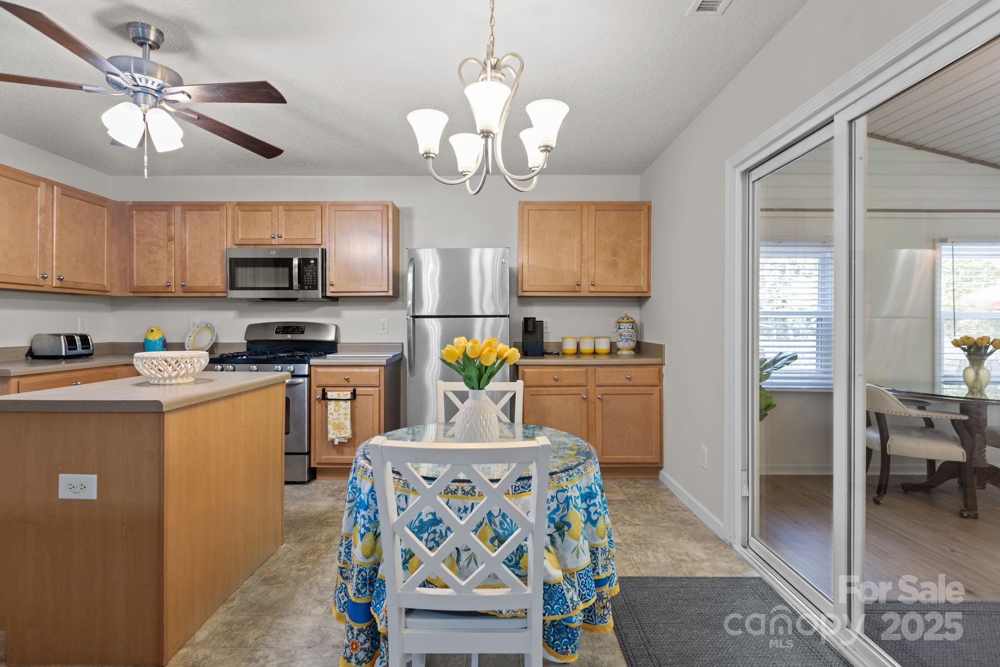 6839 Harter Court, Unit 35 Raleigh, NC 27610 - Photo 14 of 43 a kitchen with stainless steel appliances granite countertop a sink a stove a refrigerator cabinets and dining table