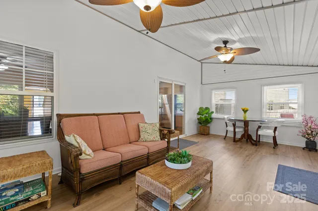 a living room with furniture kitchen view and a window