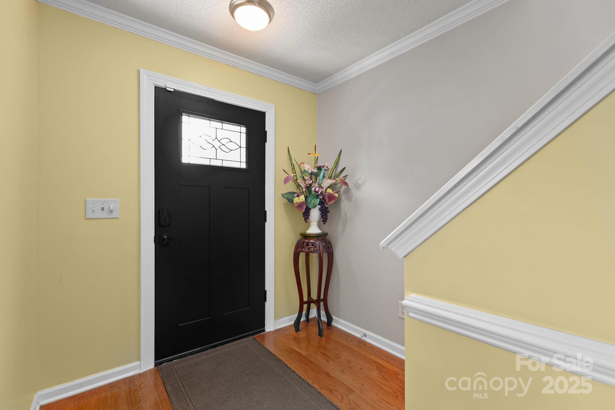 6839 Harter Court, Unit 35 Raleigh, NC 27610 - Photo 4 of 43 a view of a hallway with wooden floor and a potted plant