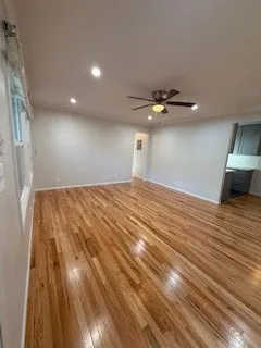 a view of a livingroom with a ceiling fan and wooden floor
