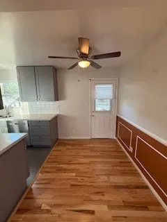 a view of an empty room with window and wooden floor