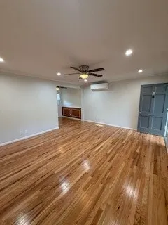 a view of empty room with wooden floor