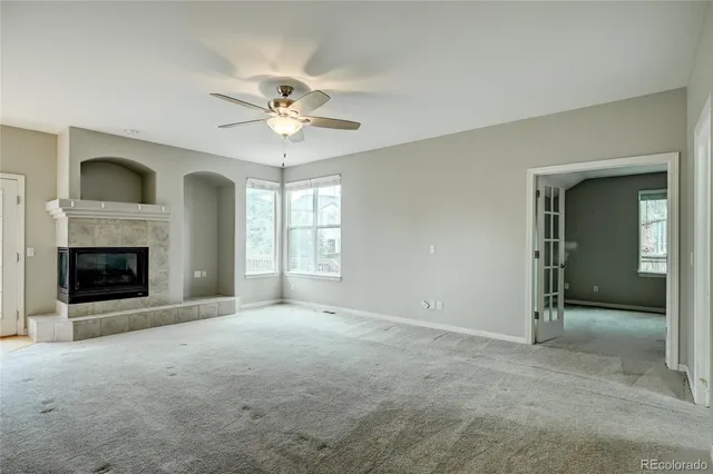 a view of a livingroom with a ceiling fan and staircase