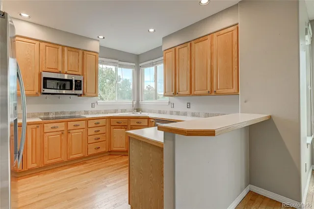 a kitchen with stainless steel appliances granite countertop a stove a sink and a microwave