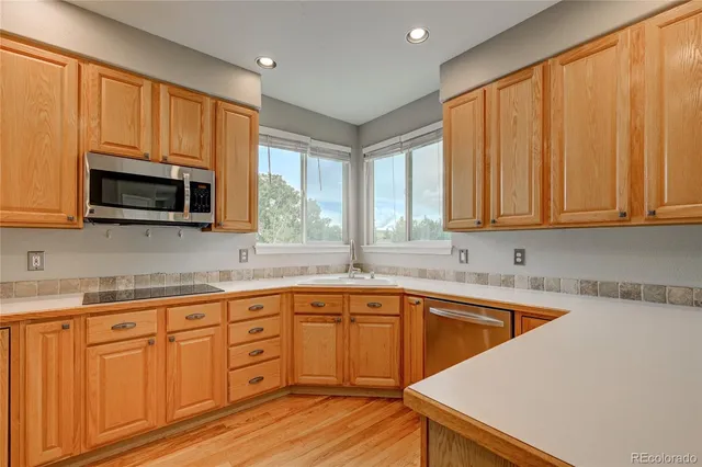 a kitchen with a refrigerator sink and cabinets