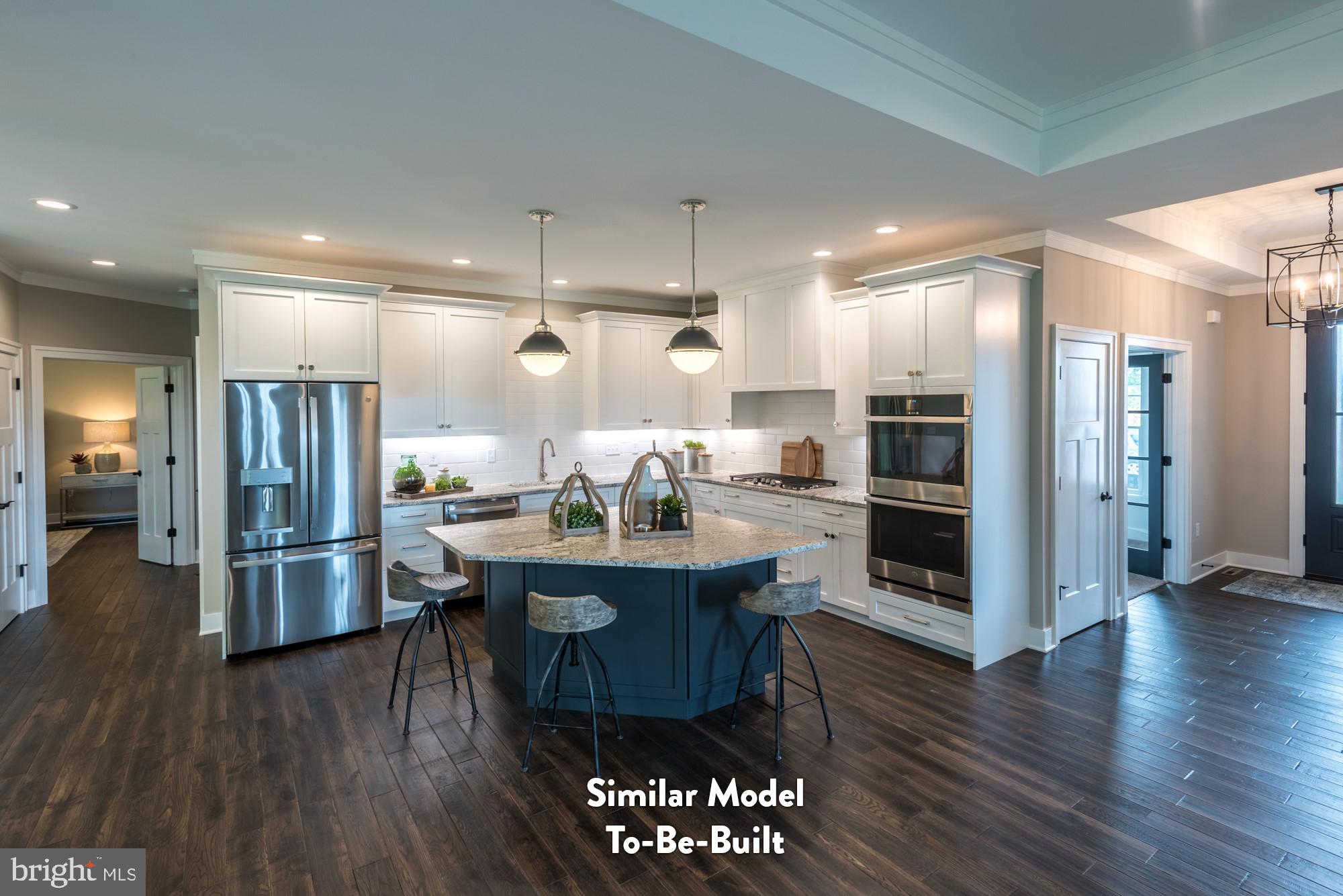 Lot#57 Patton Road Harrisburg, PA 17112 - Photo 3 of 11 a kitchen with stainless steel appliances kitchen island granite countertop a refrigerator a stove a sink and a dining table with wooden floor