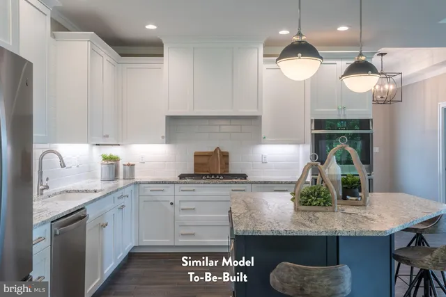 a kitchen with granite countertop kitchen island white cabinets and refrigerator