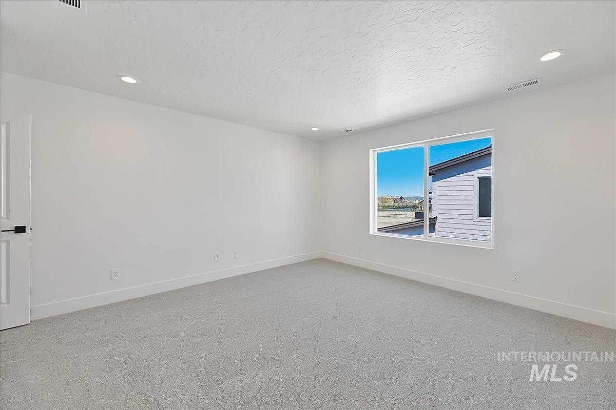 776 South Calhoun Lane Star, ID 83669 - Photo 25 of 49 Spacious room featuring light gray carpeting, crisp white walls, recessed ceiling lighting, and a large window