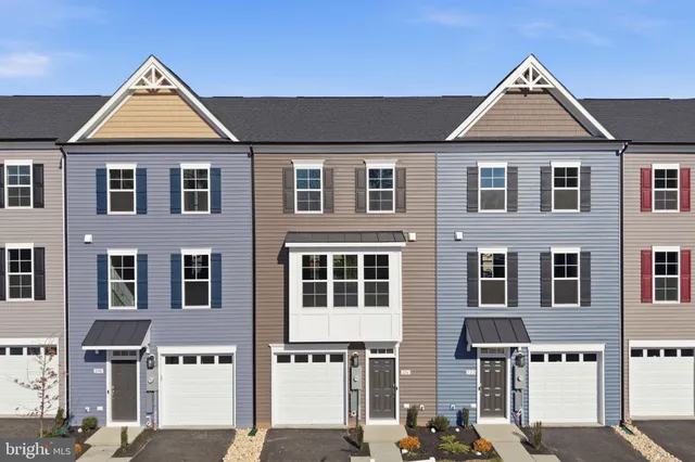 a front view of residential houses with parking