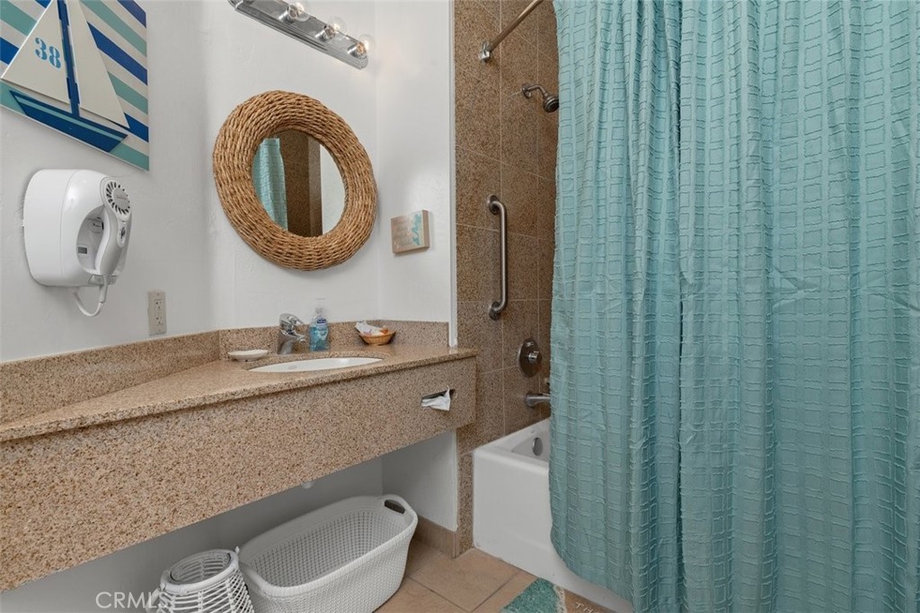 198 Main Street, Unit 205 Pismo Beach, CA 93449 - Photo 15 of 18 a bathroom with a granite countertop sink and a mirror