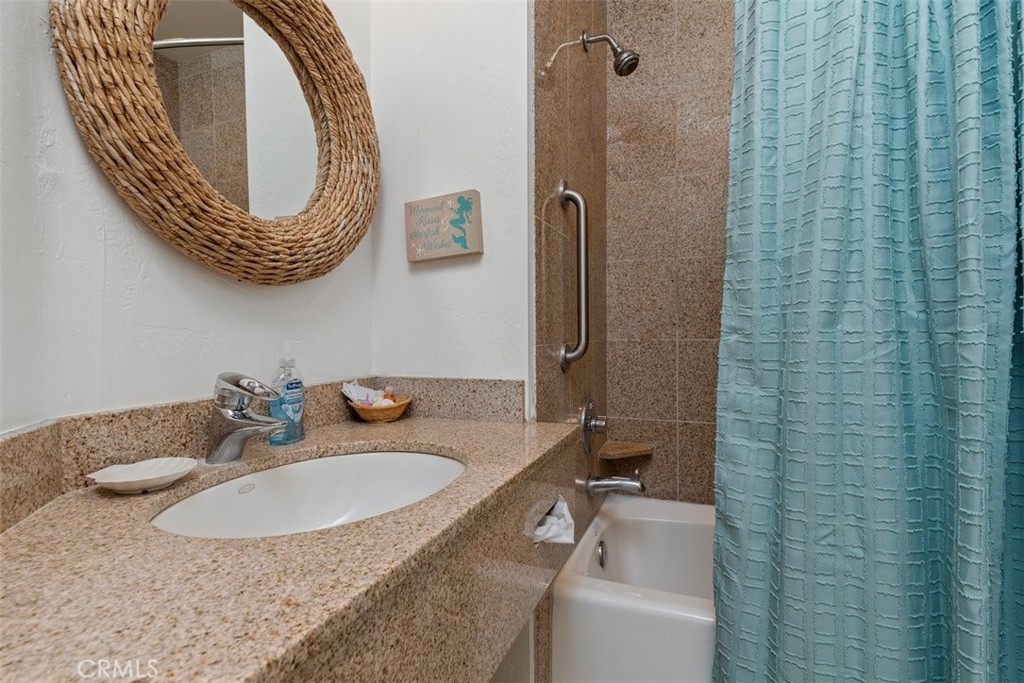 198 Main Street, Unit 205 Pismo Beach, CA 93449 - Photo 16 of 18 a bathroom with a sink a toilet and a mirror