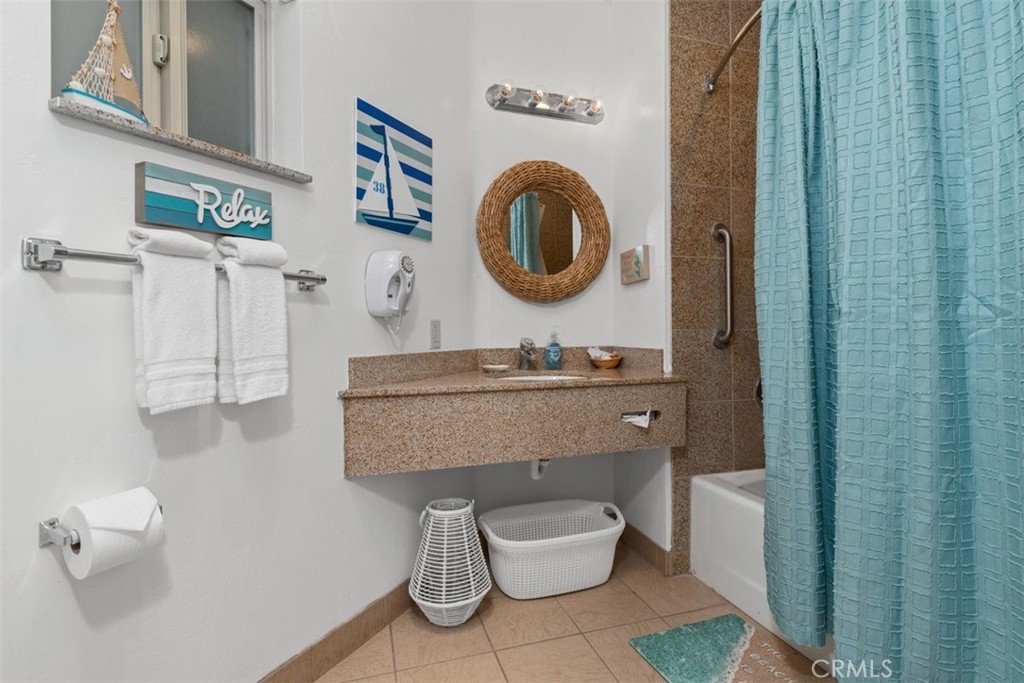 198 Main Street, Unit 205 Pismo Beach, CA 93449 - Photo 17 of 18 a bathroom with a toilet a sink and a mirror