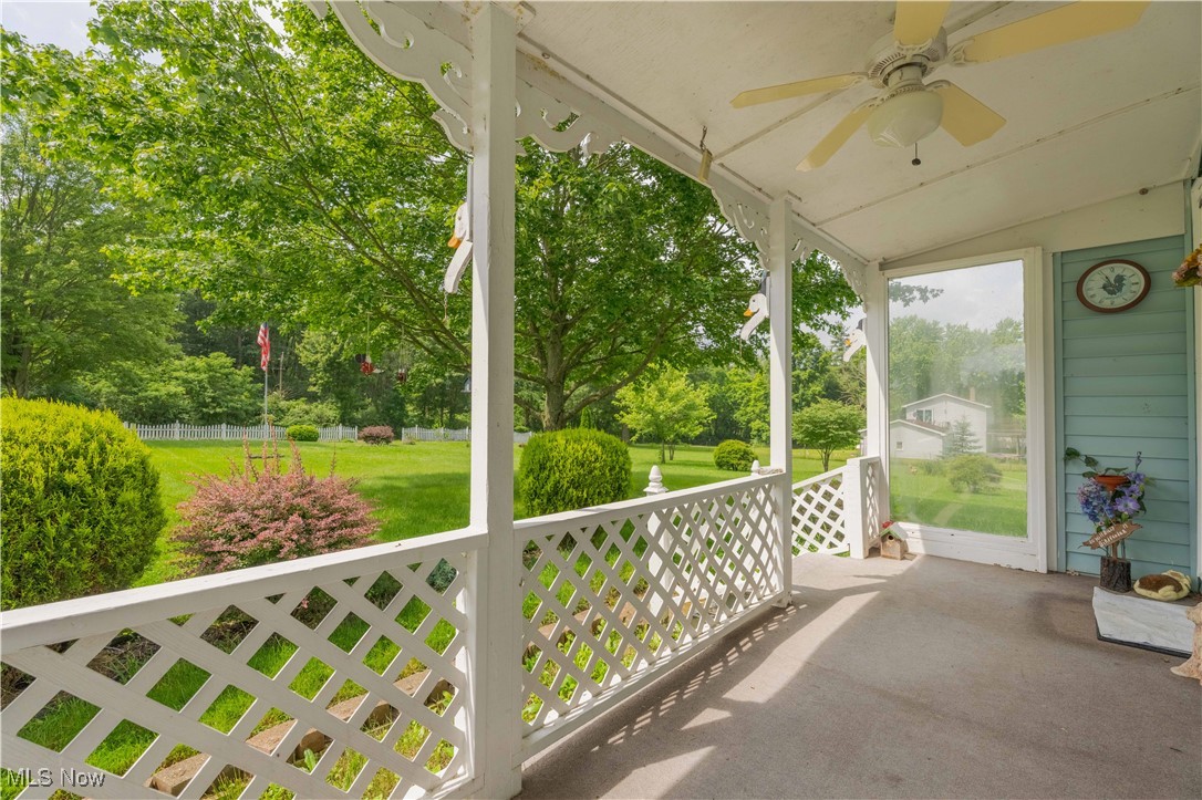 15544 West Calla Road Beloit, OH 44609 - Photo 4 of 40 Covered porch featuring a ceiling fan, a yard, and view of wooded area