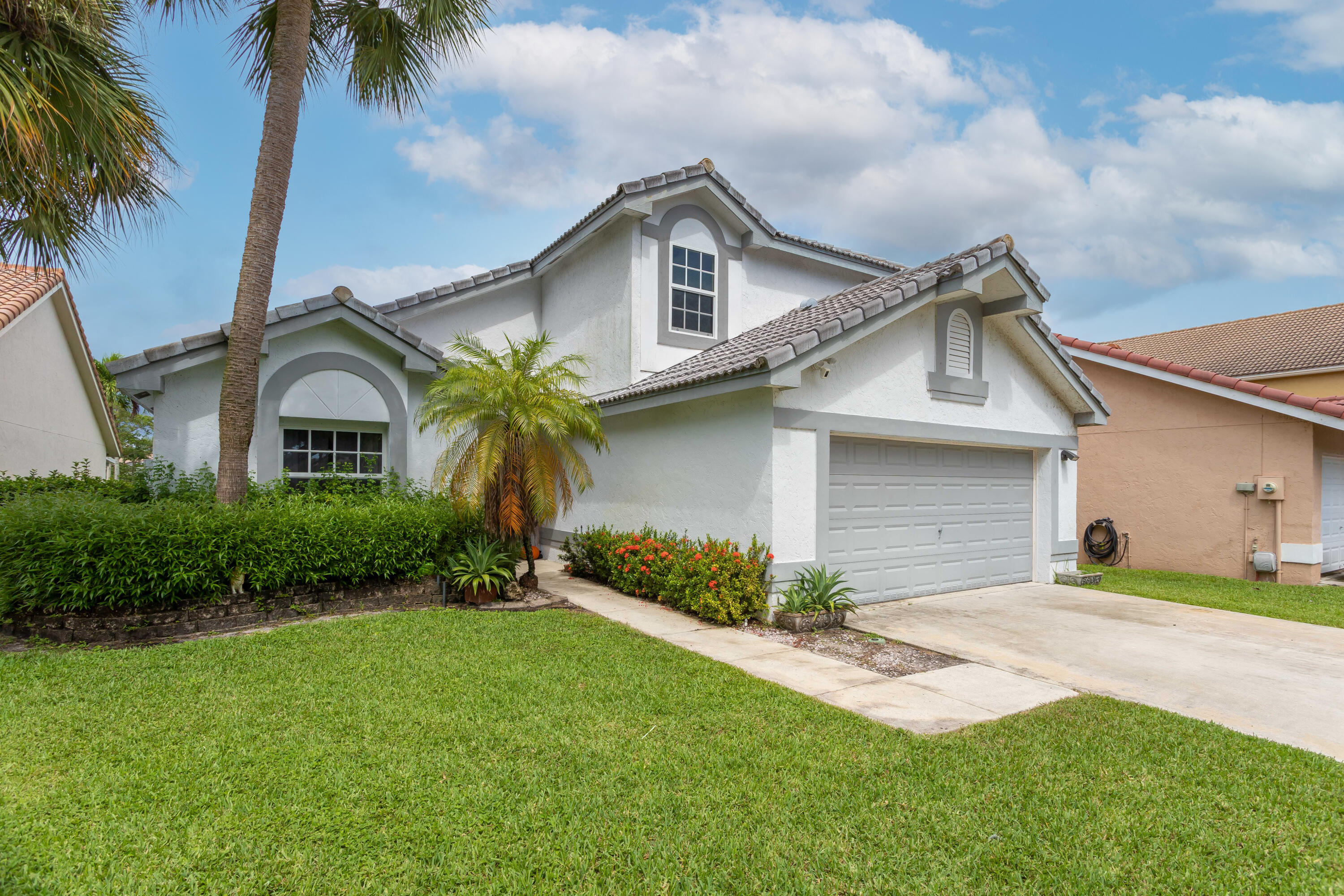 7427 Shell Ridge Terrace Lake Worth, FL 33467 - Photo 1 of 27 a front view of a house with a garden and entryway