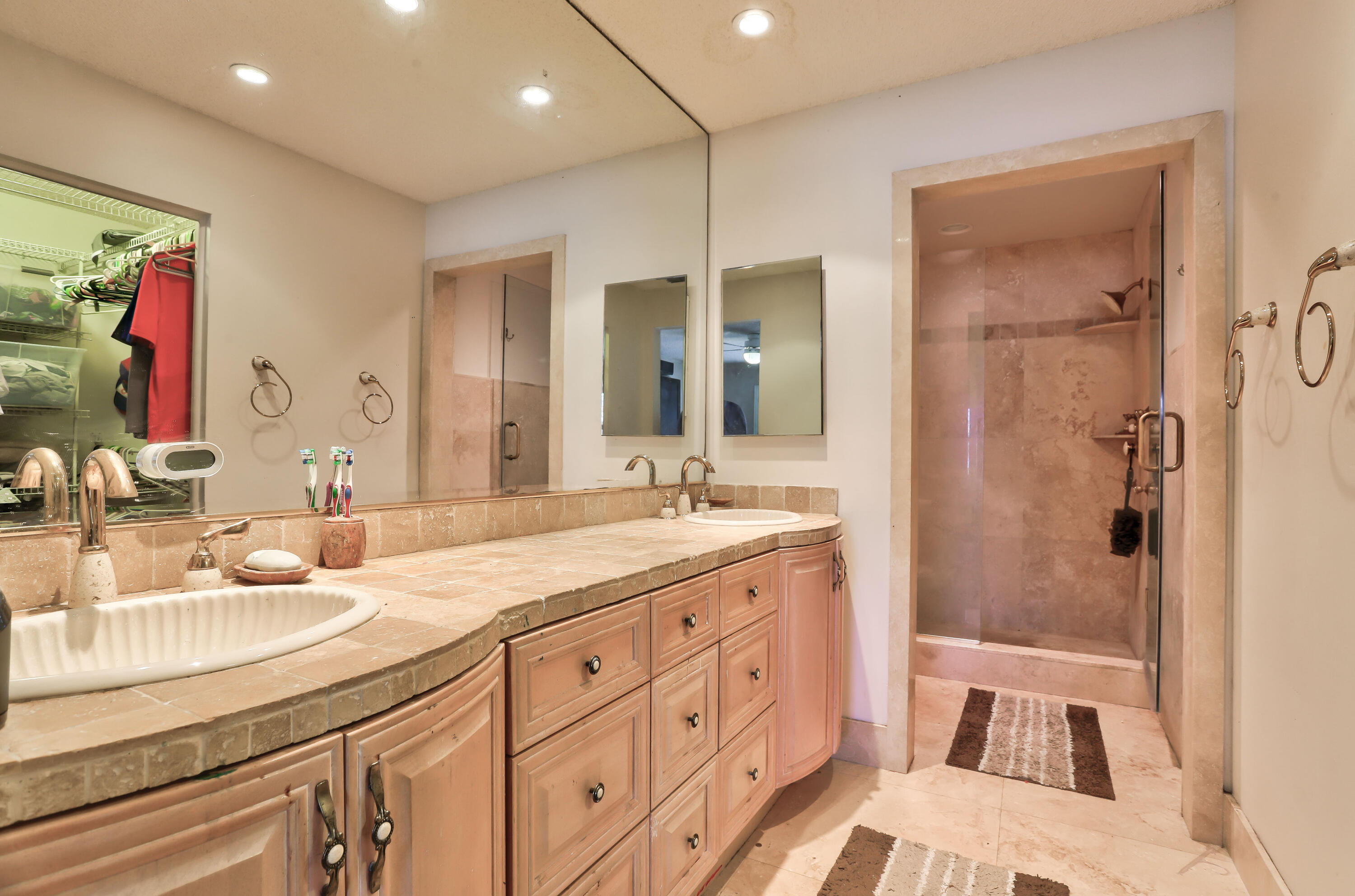 7427 Shell Ridge Terrace Lake Worth, FL 33467 - Photo 24 of 27 a bathroom with a double vanity sink a mirror and a shower