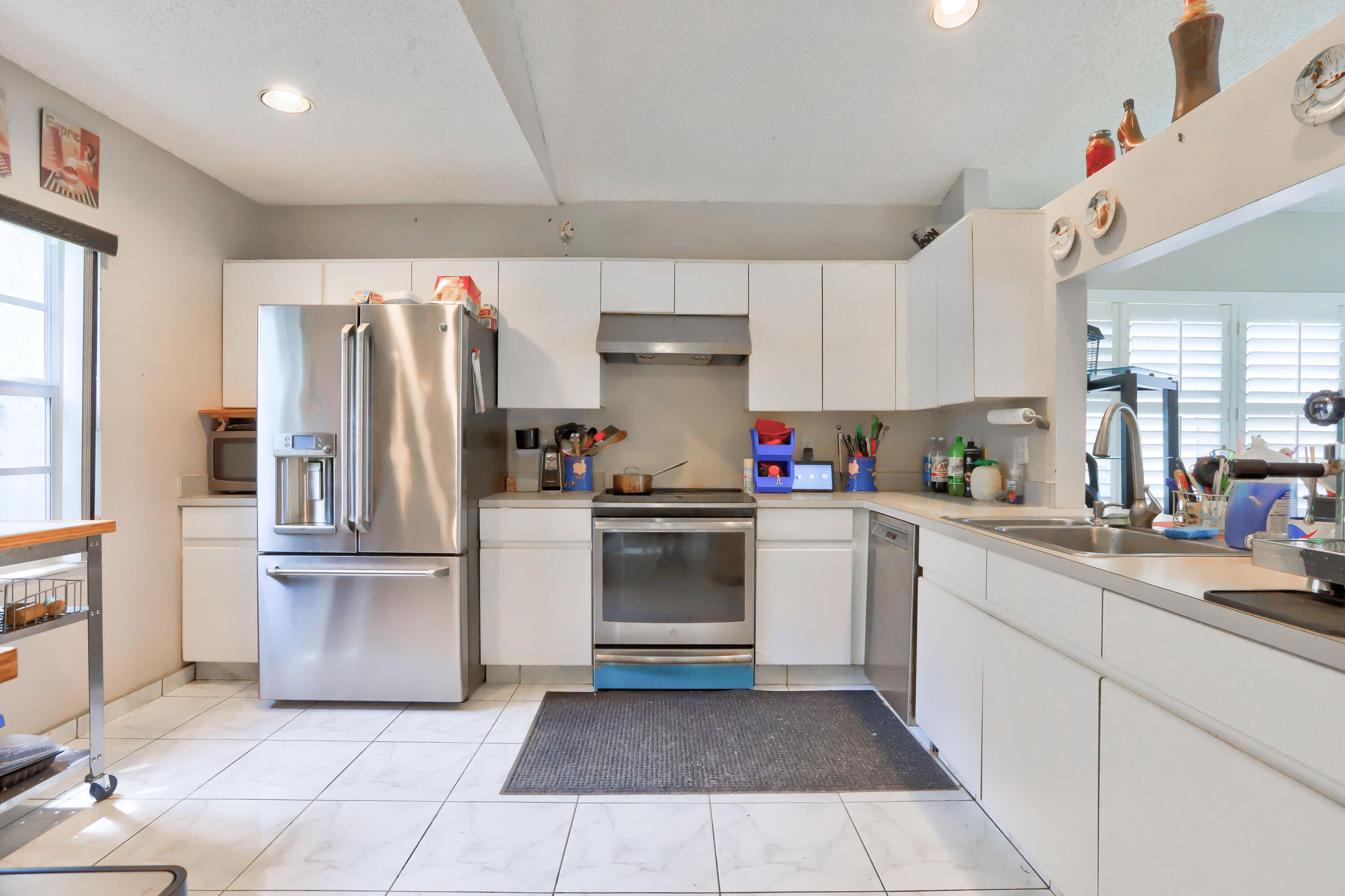 7427 Shell Ridge Terrace Lake Worth, FL 33467 - Photo 6 of 27 a kitchen with stainless steel appliances granite countertop a refrigerator sink and cabinets