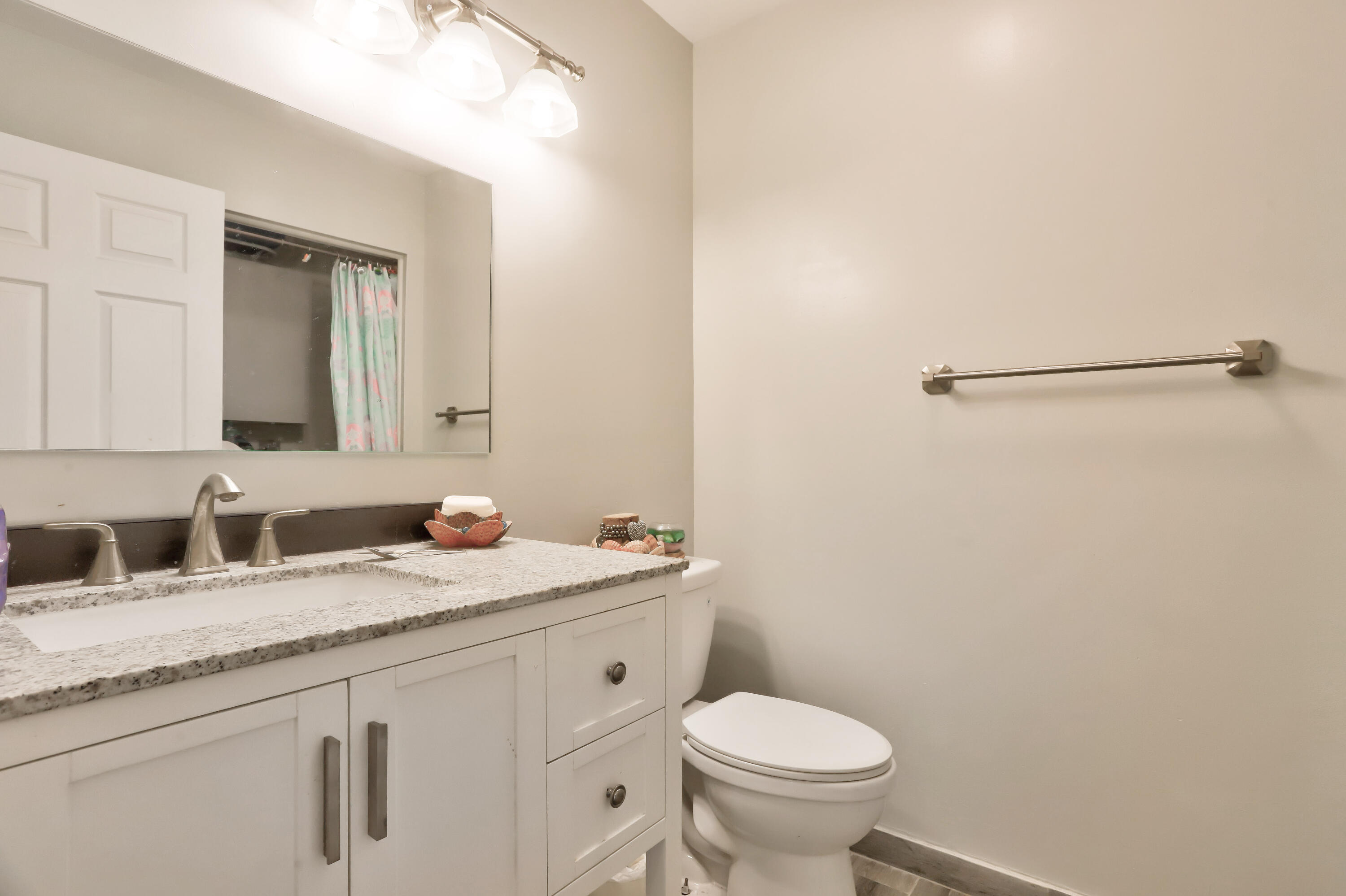 7427 Shell Ridge Terrace Lake Worth, FL 33467 - Photo 9 of 27 a bathroom with a granite countertop sink mirror vanity and toilet