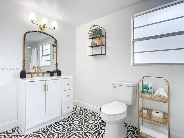 a bathroom with a toilet a sink and mirror