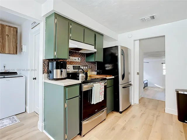 a kitchen with a sink cabinets and stainless steel appliances