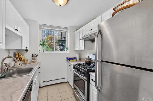 a kitchen with granite countertop a sink stove and refrigerator