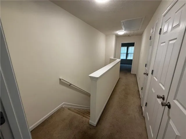 an empty room with chandelier fan and windows