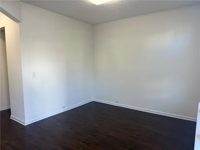 a view of a small space with wooden floor and a window