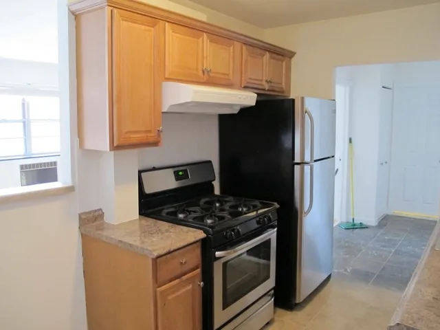 a kitchen with stainless steel appliances granite countertop a refrigerator and a stove