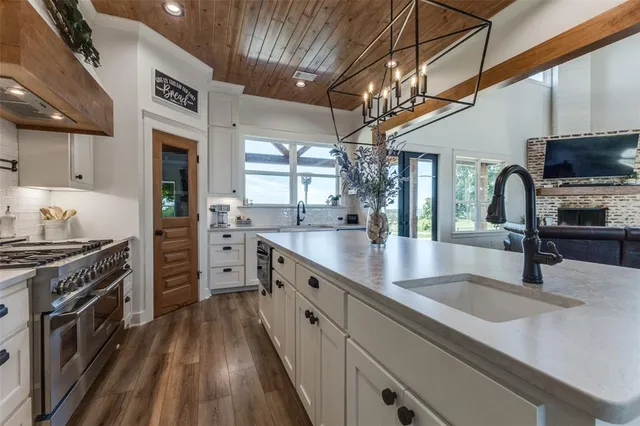 a kitchen with stainless steel appliances granite countertop a sink a stove and cabinets