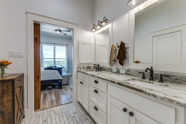 a en suite bathroom with a granite countertop sink and a mirror
