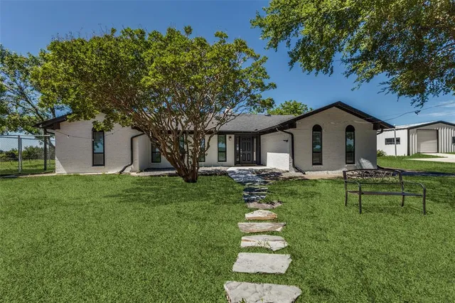 a front view of house with a garden