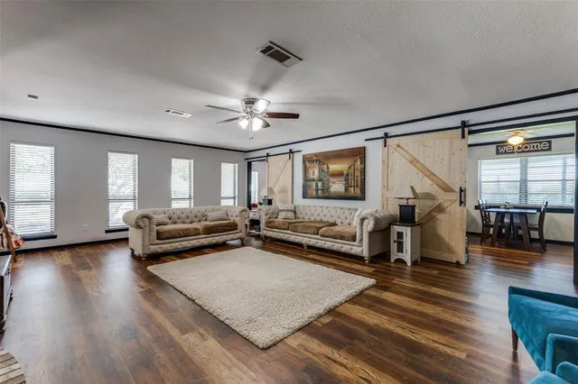 a living room with furniture and a wooden floor