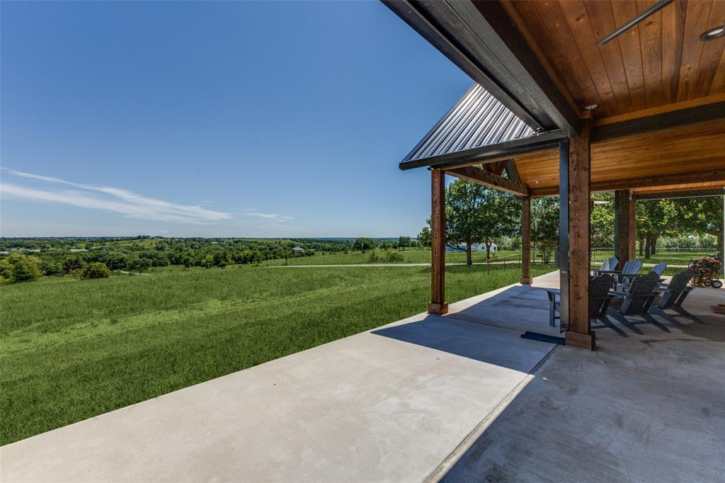 917 Marlow Road Bells, TX 75414 - Photo 3 of 40 a view of a patio with table and chairs under an umbrella with a yard