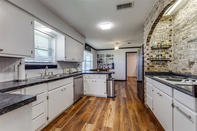 a kitchen with granite countertop a sink appliances cabinets and counter space