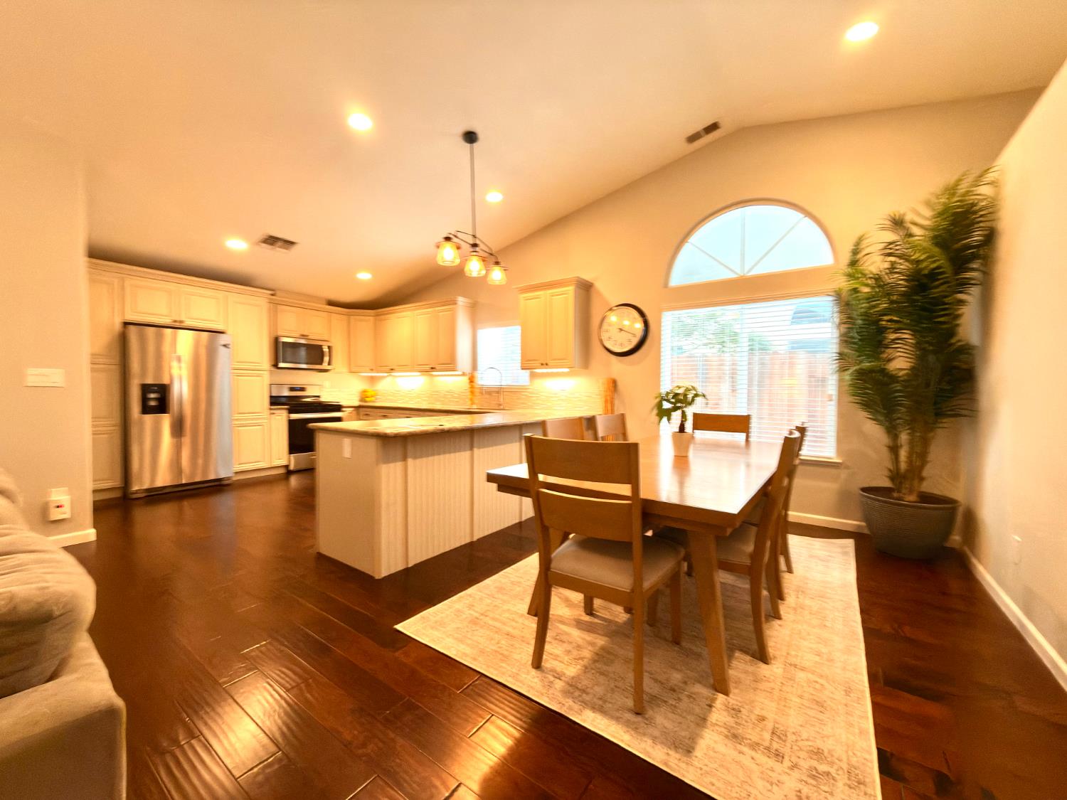 775 Oldenburg Way Galt, CA 95632 - Photo 5 of 31 a kitchen with stainless steel appliances kitchen island granite countertop a stove a refrigerator a dining table and chairs with wooden floor