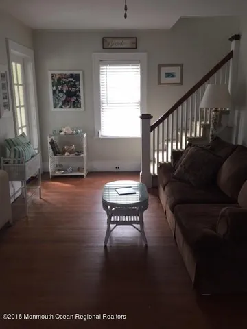 a living room with furniture wooden floor and a window