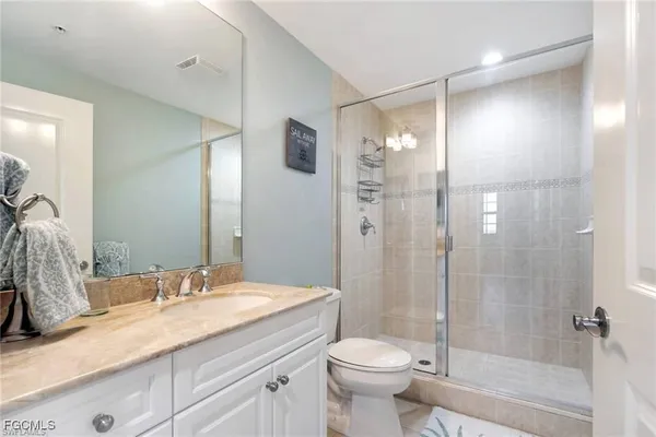 a bathroom with a granite countertop sink toilet and shower