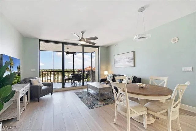 a dining room with furniture water view and a floor to ceiling window