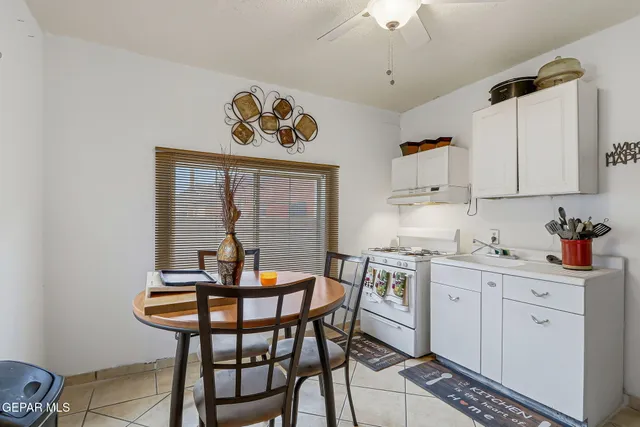 a kitchen with stainless steel appliances granite countertop a sink a stove and white cabinets