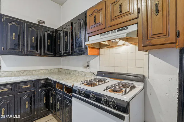 a kitchen with a stove a sink and cabinets