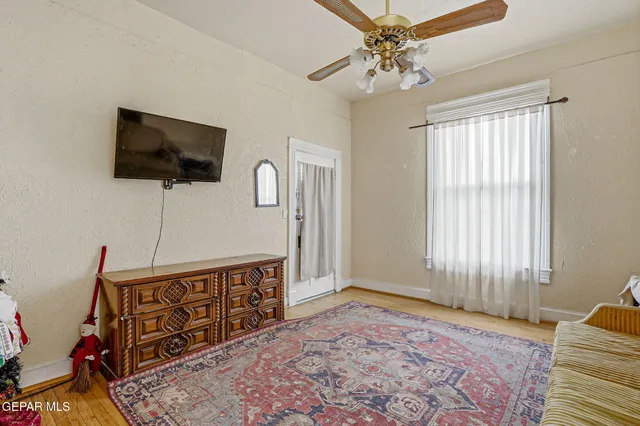 a bedroom with a bed wooden floor and window