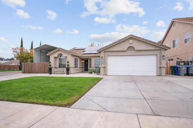 a front view of a house with a garden and yard