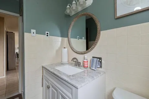a bathroom with a granite countertop toilet sink and mirror