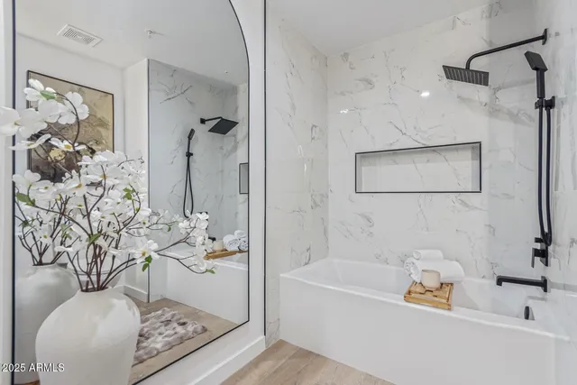 a bathroom with a tub a sink and glass door shower