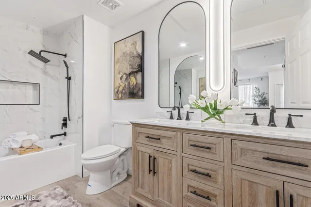 a bath room with a toilet a sink and a mirror