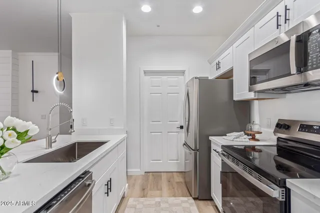 a kitchen with stainless steel appliances a sink a stove and a refrigerator