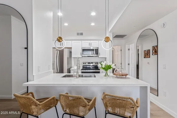 a room with stainless steel appliances kitchen island granite countertop furniture and a view of kitchen