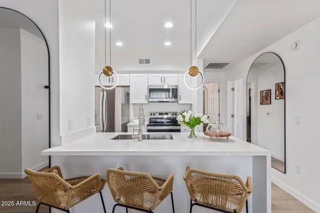 a room with stainless steel appliances kitchen island granite countertop furniture and a view of kitchen