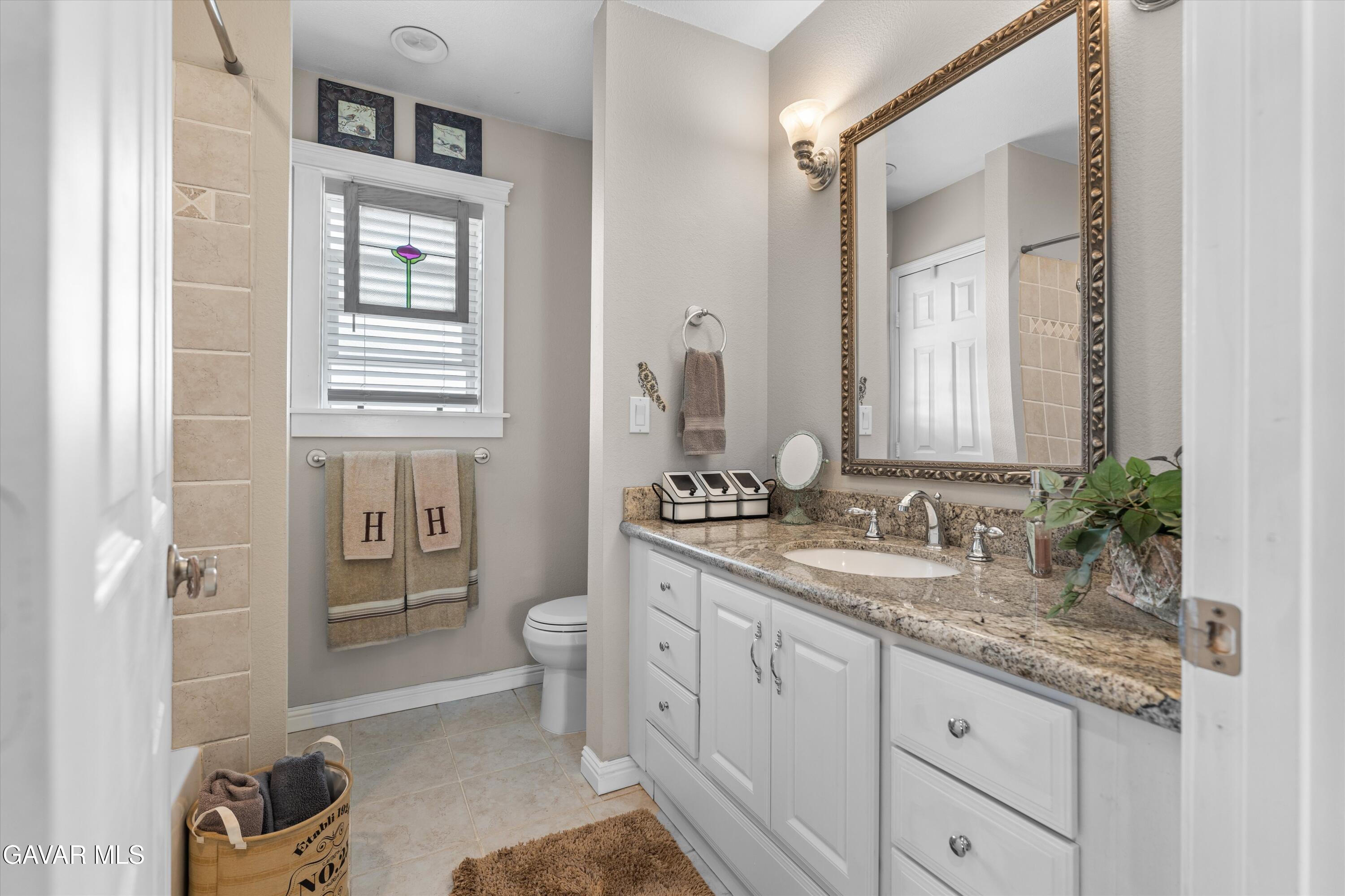 27450 Harness Drive Tehachapi, CA 93561 - Photo 19 of 44 a spacious bathroom with a granite countertop sink and a mirror