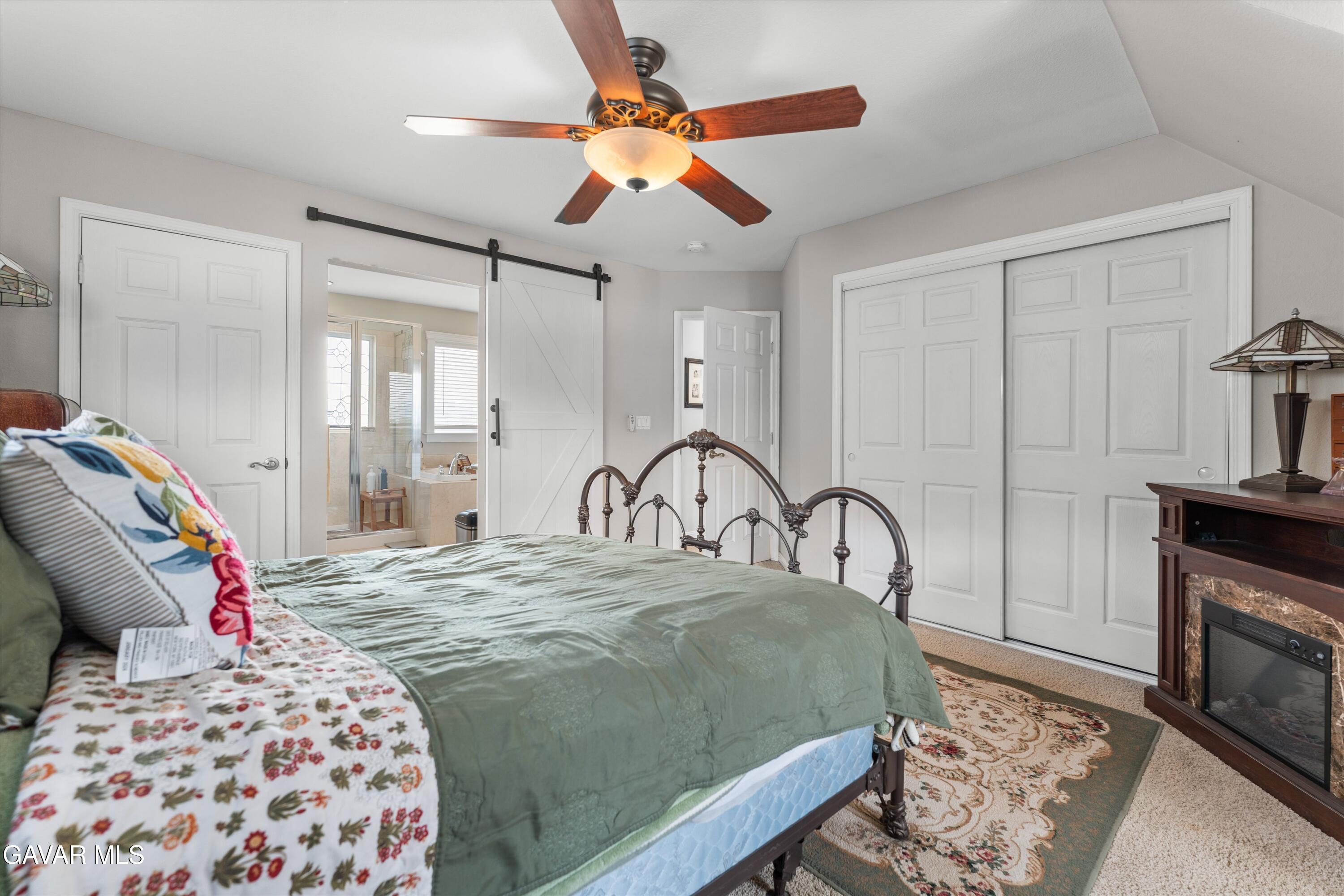 27450 Harness Drive Tehachapi, CA 93561 - Photo 21 of 44 a bedroom with a large bed and a fireplace